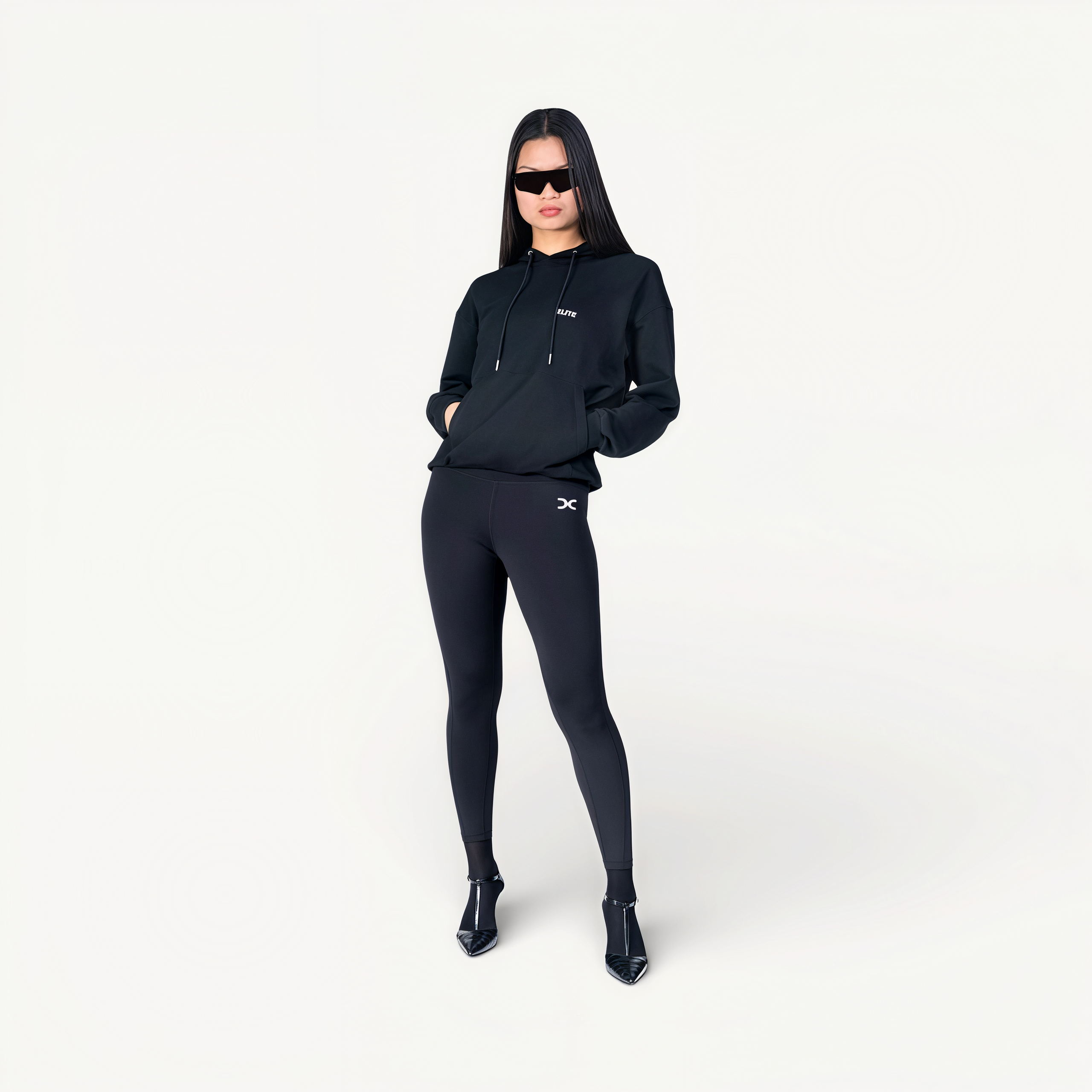 Woman wearing a black hoodie and leggings with ‘Elite’ ENVOLE logo front view.