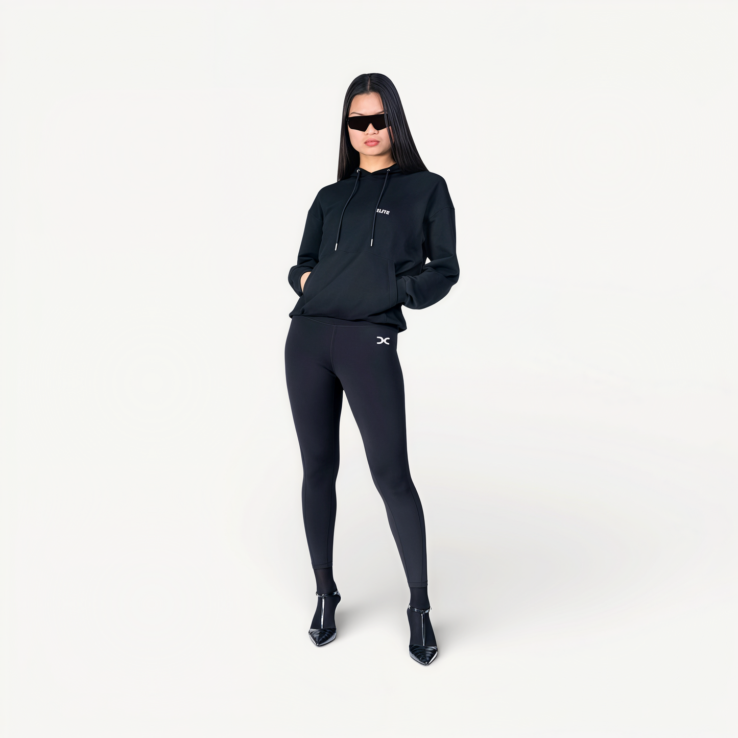 Woman wearing a black hoodie and leggings with ‘Elite’ ENVOLE logo front view.