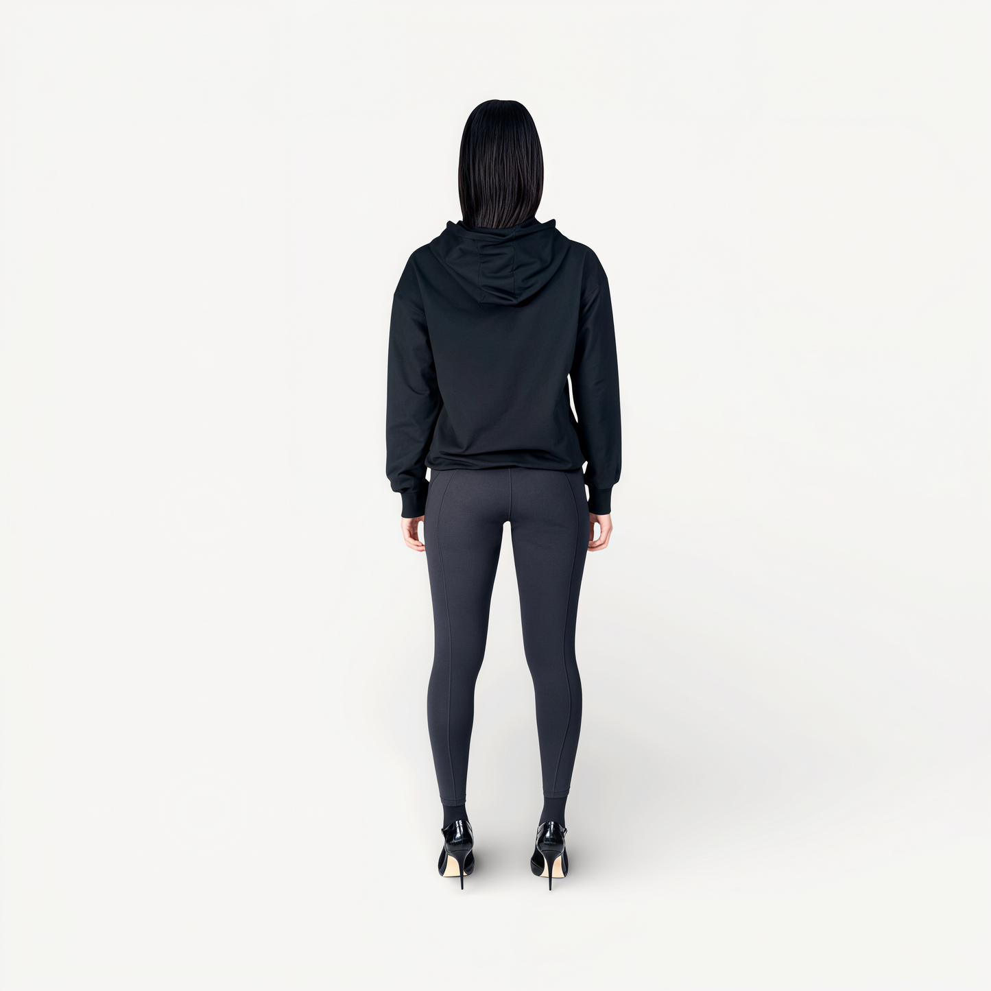 Woman wearing a black hoodie and leggings with ‘Elite’ ENVOLE logo back view.