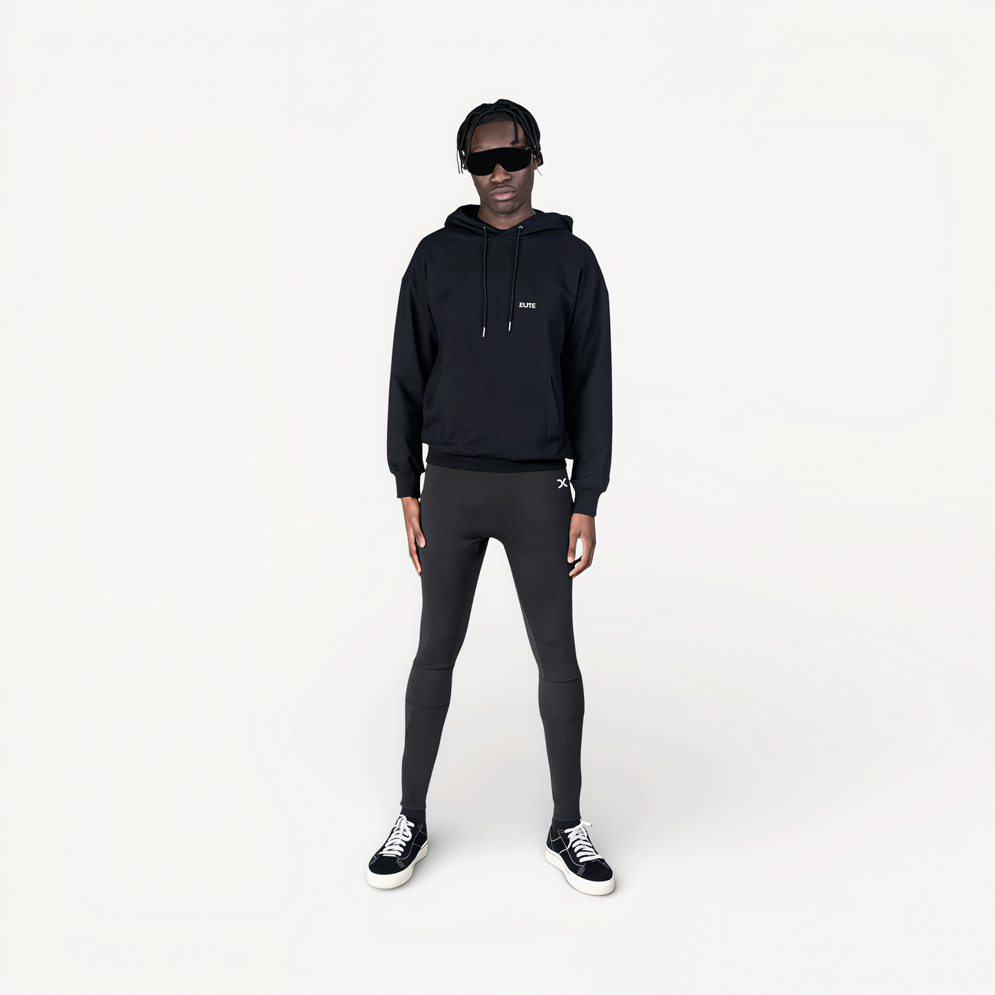 Person wearing a black hoodie and leggings with ENVOLE branding on a white background.