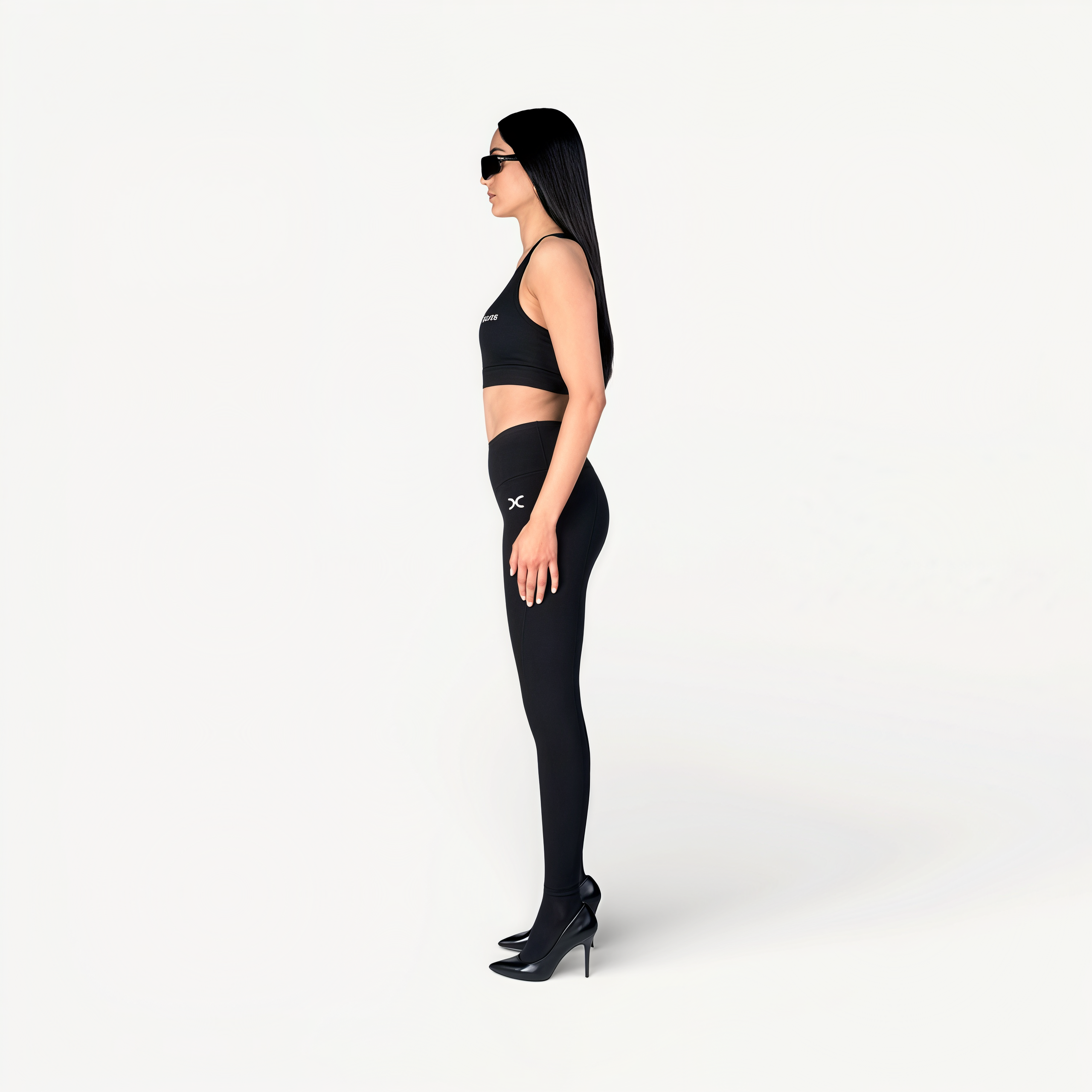 Woman wearing a black athletic outfit with ‘Elite’ ENVOLE logo on a white background.