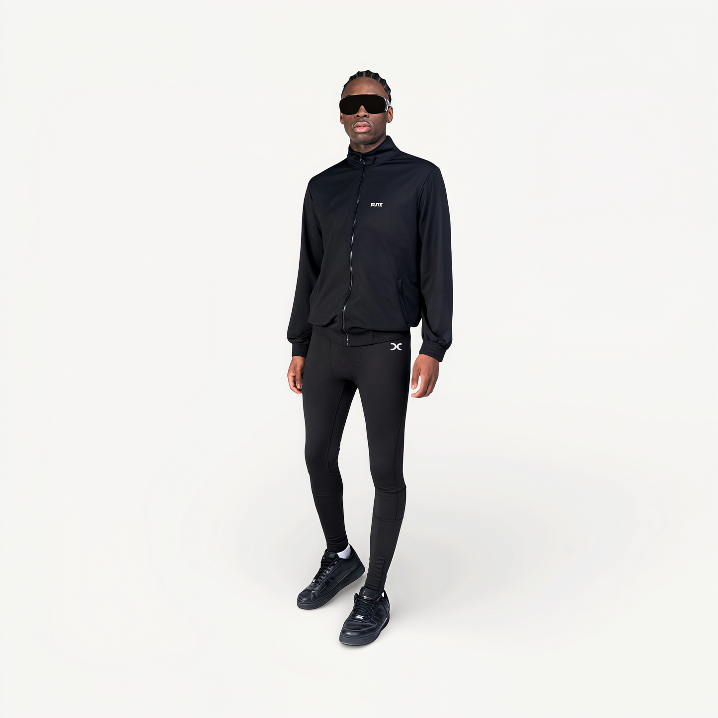 Man wearing a black tracksuit with ‘Elite’ ENVOLE branding.