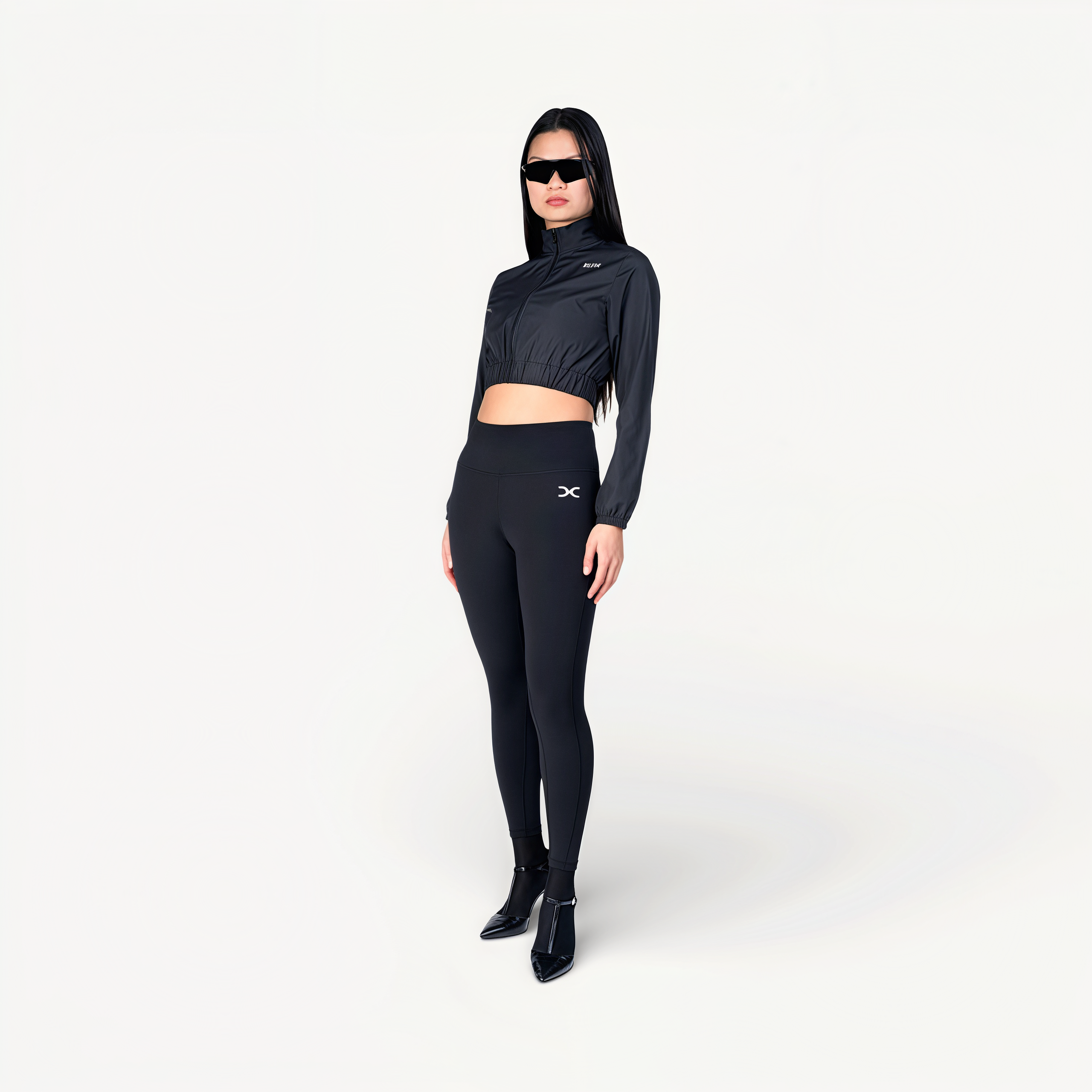 Woman wearing a black athletic outfit on a white background front view.