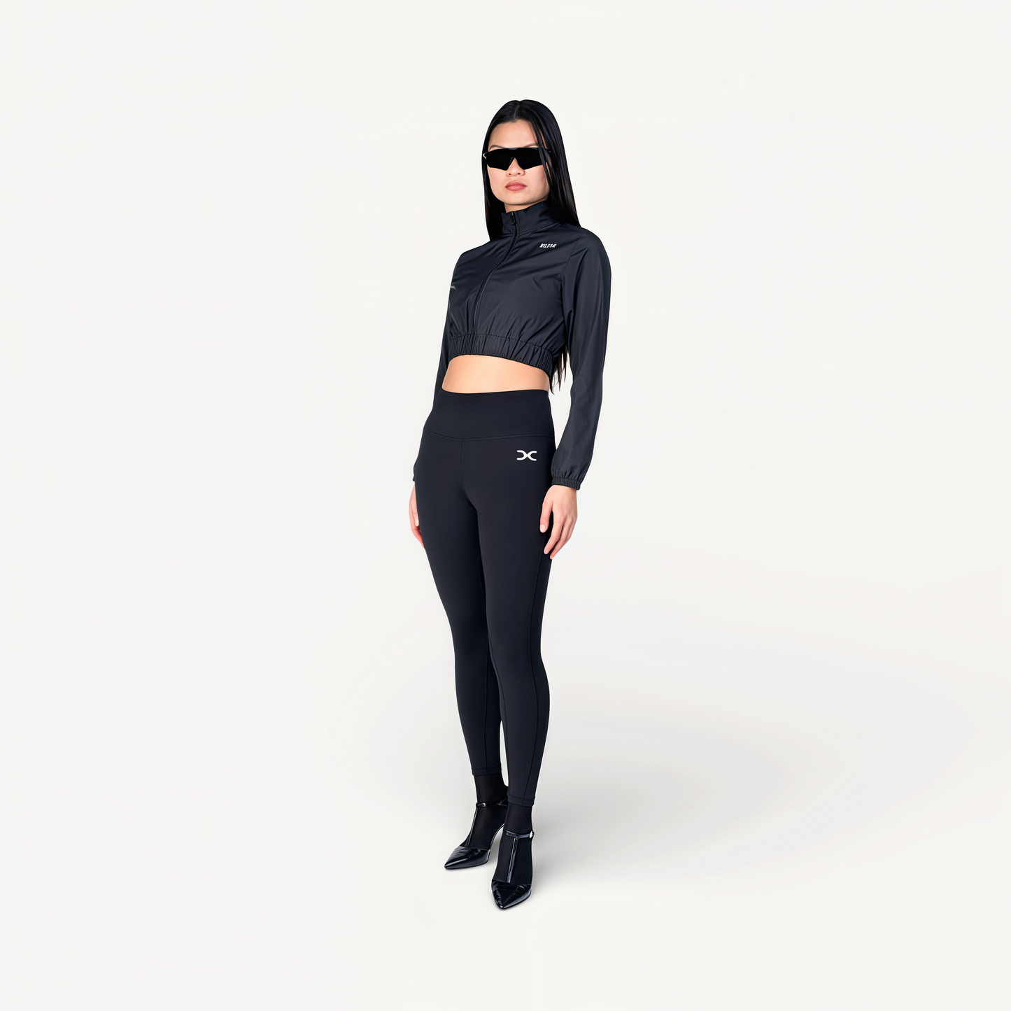 Woman wearing a black athletic outfit on a white background front view.