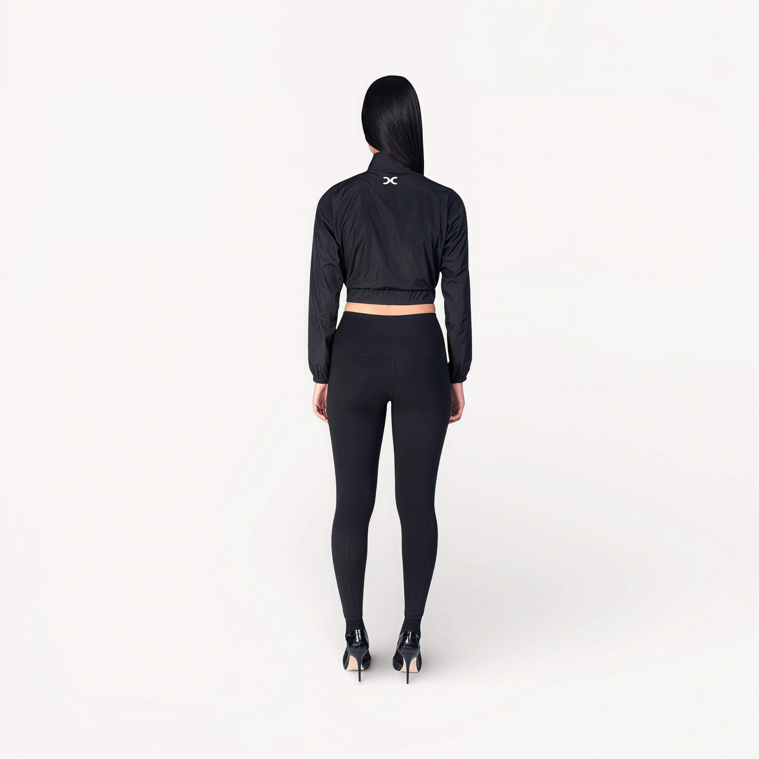 Woman wearing a black athletic outfit with ENVOLE branding back view.