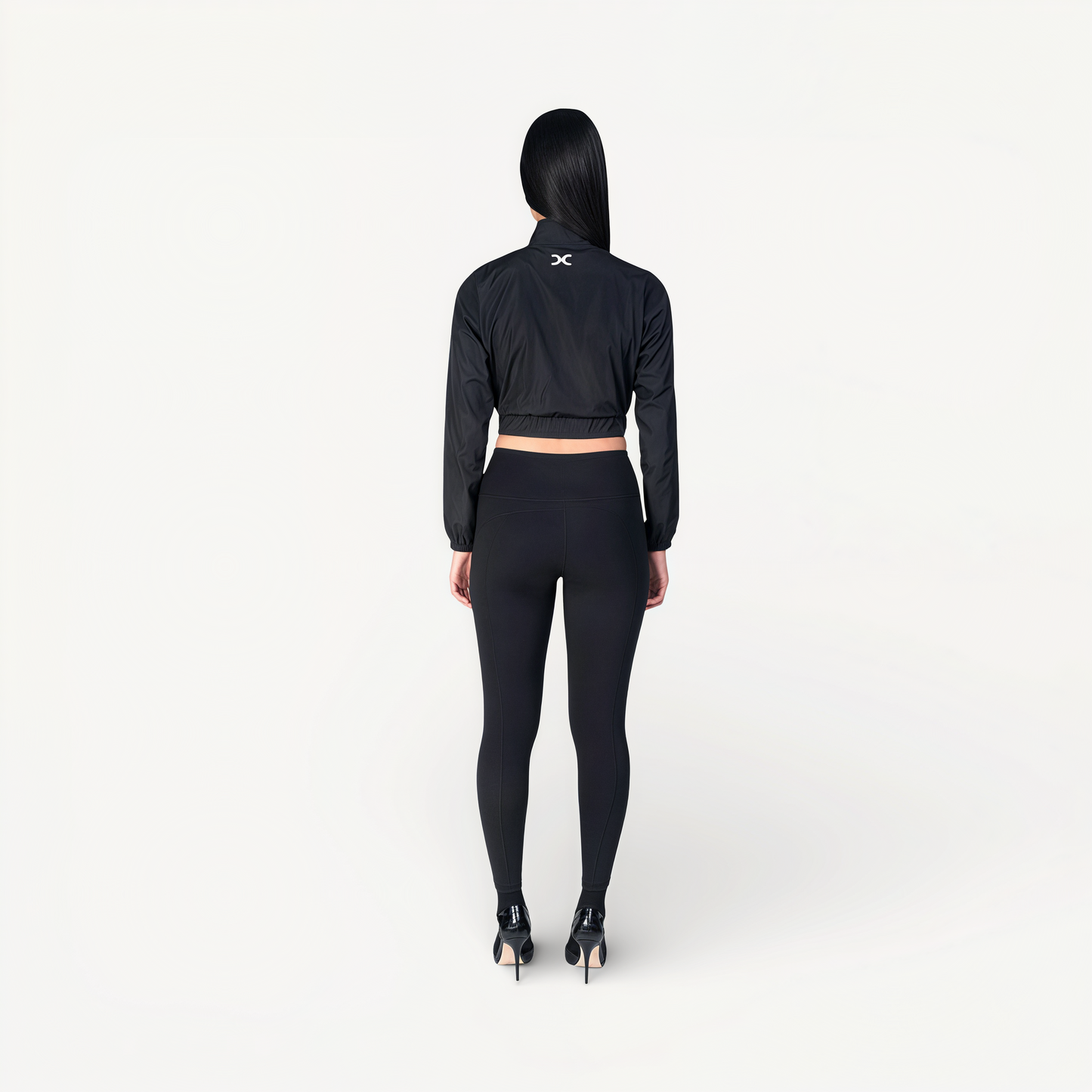Woman wearing a black athletic outfit with ENVOLE branding back view.